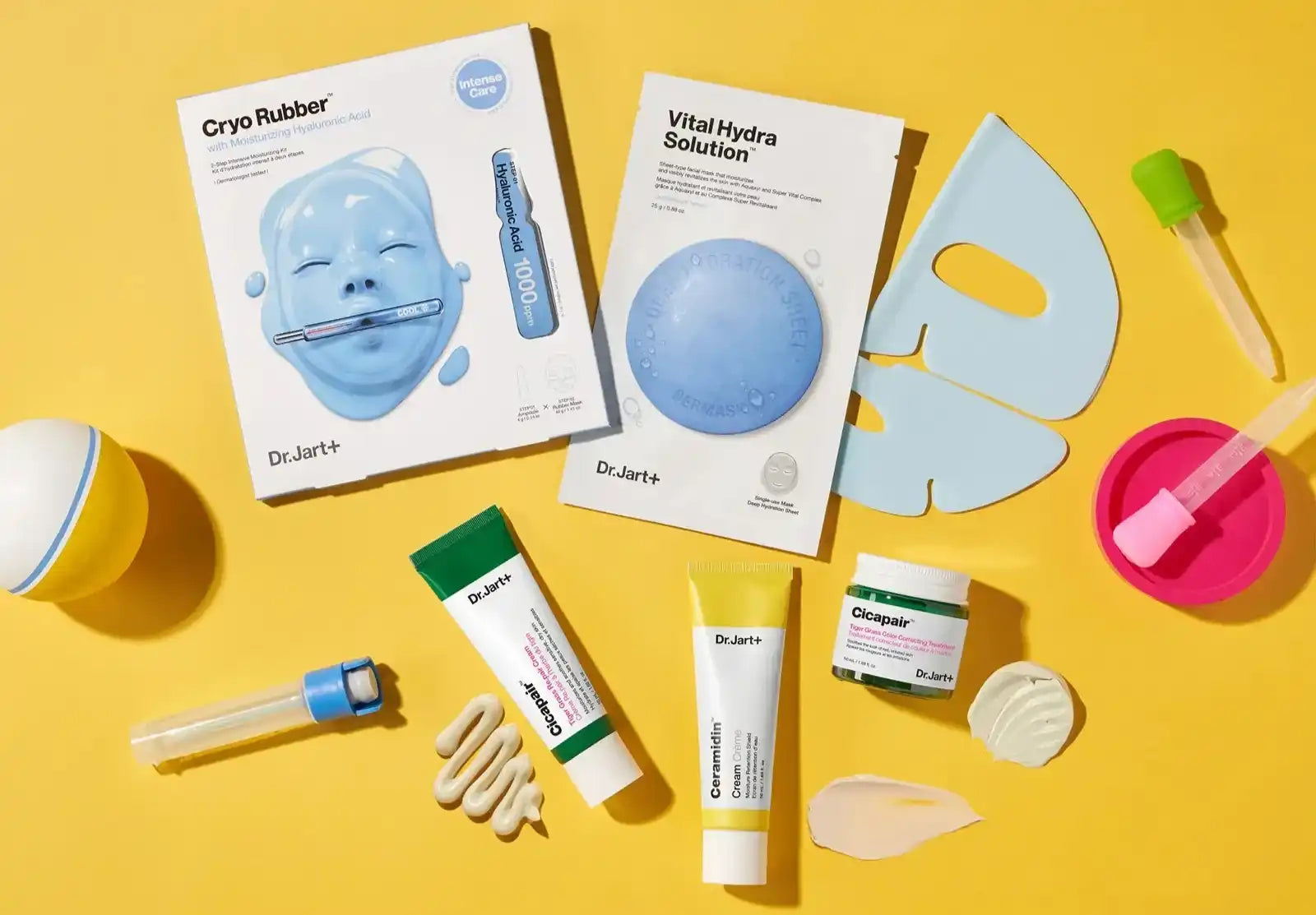 Collection of Korean skincare products and beauty tools laid out on a yellow surface.